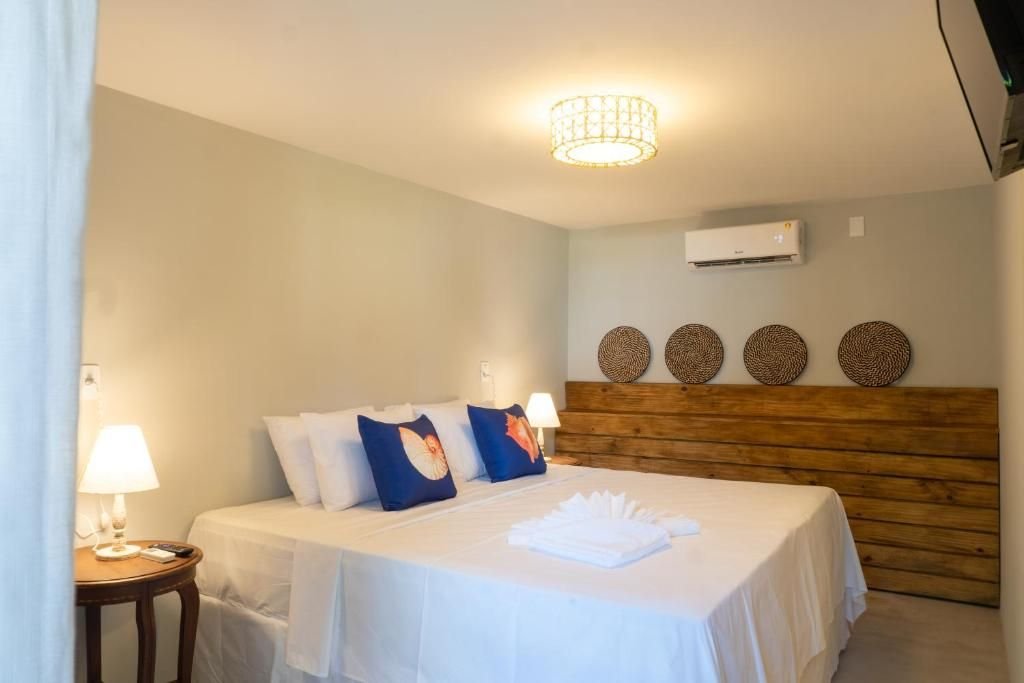 Cama de casal com almofadas e cabeceira de madeira