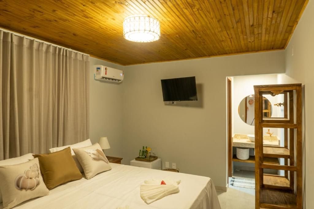 Suíte com forro de madeira, cama de casal e ar-condicionado split